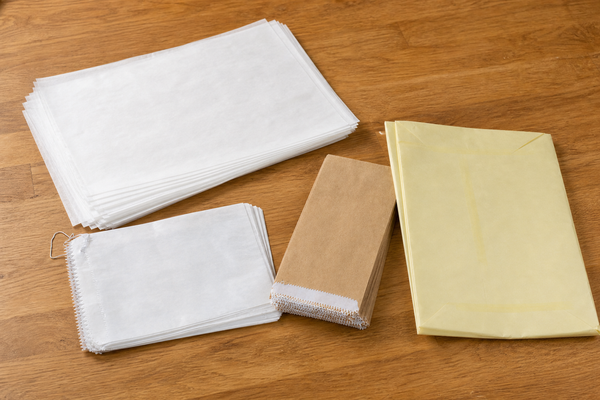 Greaseproof paper sheets and white and brown greaseproof paper bags for food service