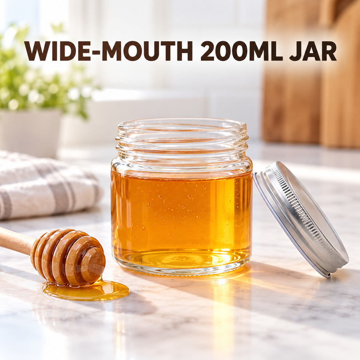 Wide-mouth 200ml glass jar filled with honey on a kitchen bench