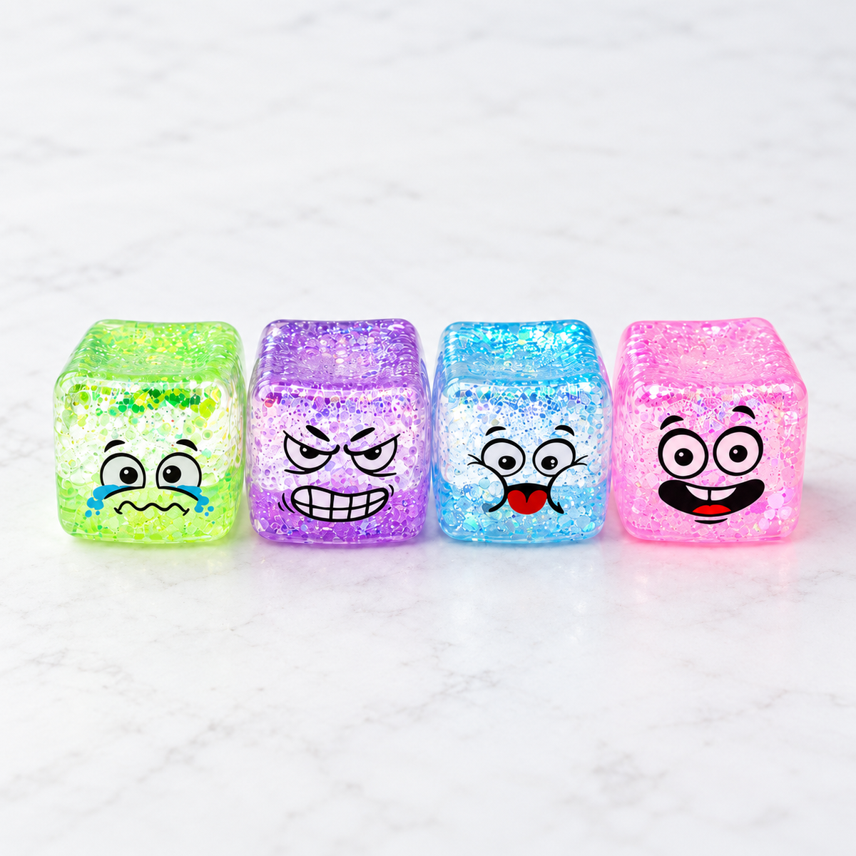 Four glitter-gel squishy cube toys in assorted colours with printed cartoon smiley faces